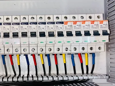 Row of circuit breakers with color-coded wiring in a professionally installed electrical panel